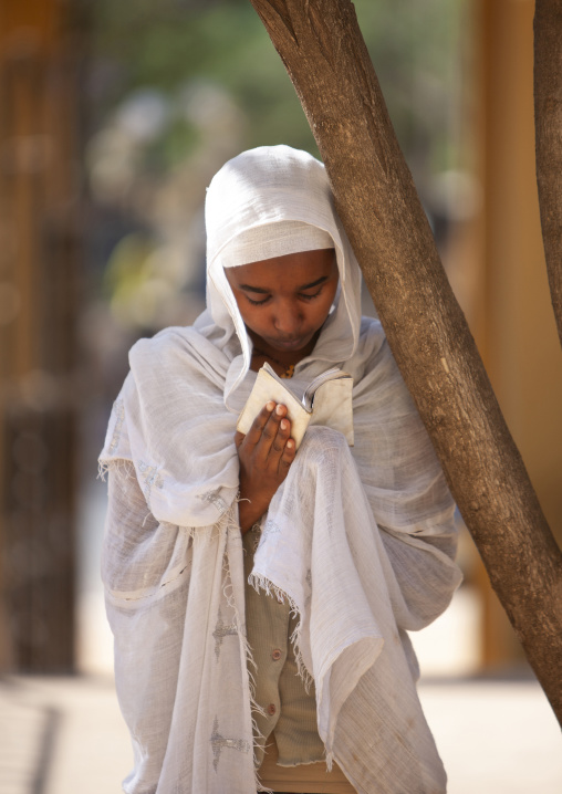 Portrait of an orthodox woman praying with a bible, Harari Region, Harar, Ethiopia