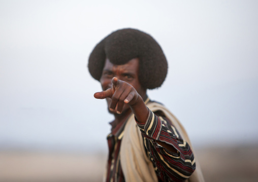 Karrayyu tribe man with gunfura hairstyle pointing finger, Oromia, Metehara, Ethiopia