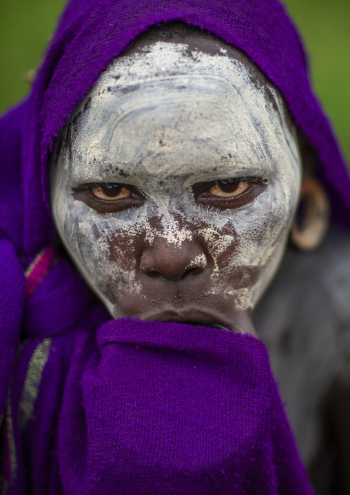 Young surma woman hiding her lip plate under her shawl, Omo valley, Kibish, Ethiopia