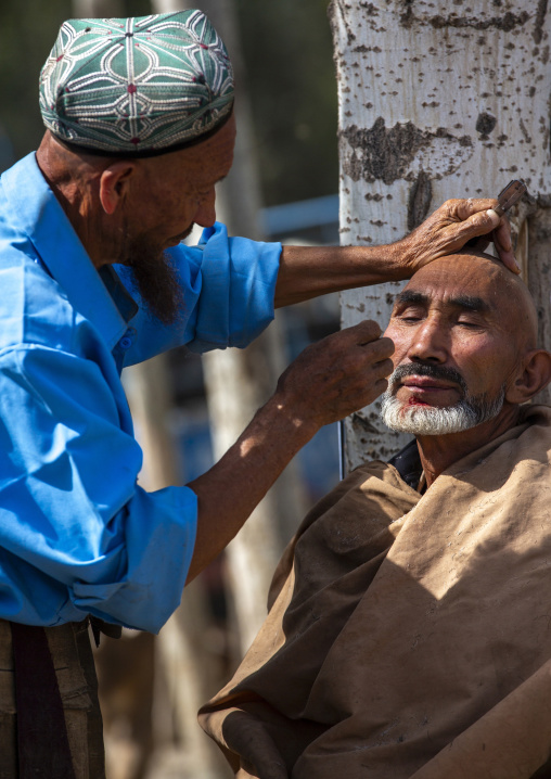 Uyghur barber shaving a customer, Opal, Xinjiang uyghur autonomous region, China