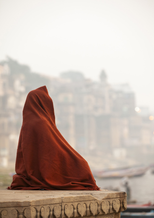 Man covered with a blanket meditating on riverbank, Uttar Pradesh, Varanasi, India