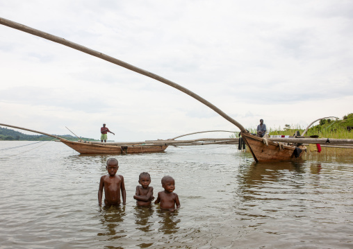Boys in the water in front of traditional boats, Lake kivu, Gisenye, Rwanda