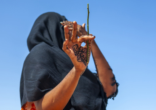 A woman with henna tattoo is hiding her face, Sahil region, Berbera, Somaliland