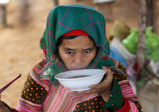 Flower Hmong woman drinking a bowl of soup, Lao Cai province, Sapa, Vietnam