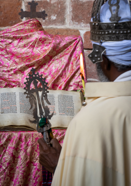 Ethiopian orthodox priest with an old bible in nakuto lab rock church, Amhara Region, Lalibela, Ethiopia