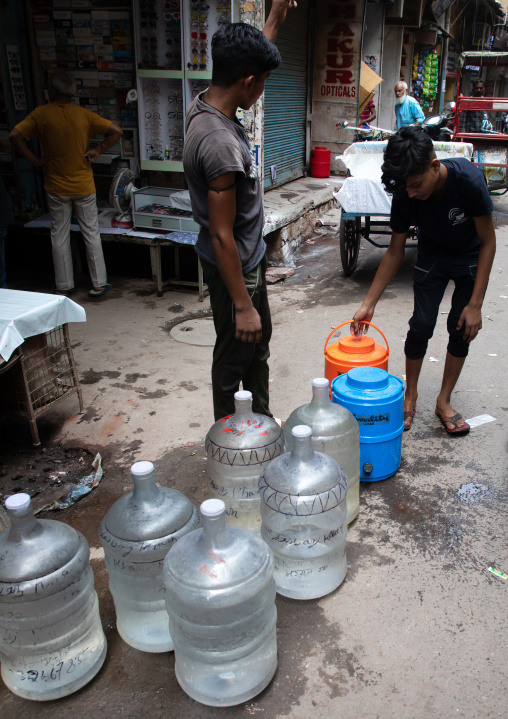 Men carrying plastic bottled water in old Delhi, Delhi, New Delhi, India