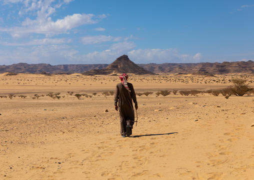 Saudi man walking in the desert, Najran Province, Thar, Saudi Arabia