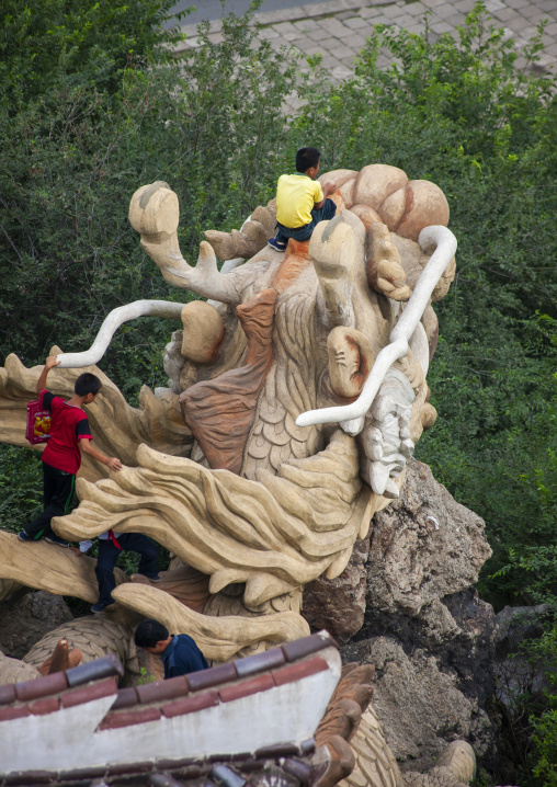 Children climbing on a Dragon statue, North Hwanghae, Sariwon, North Korea
