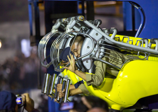 North Korean men in a fairground attraction at Kaeson youth park, DGC, Pyongyang, North Korea