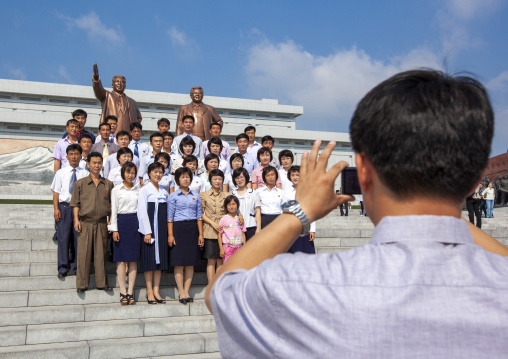 People posing in front of the statues of the Leaders in the Grand monument, DGC, Pyongyang, North Korea