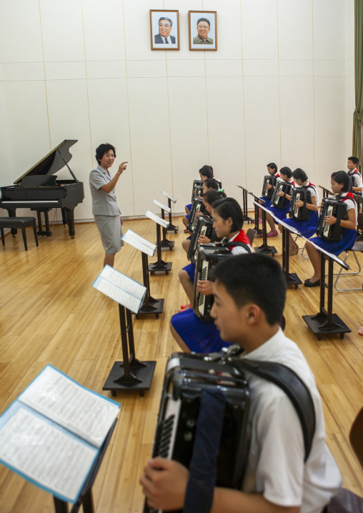 Accordion classroom in children's palace under the portraits of the Leaders, DGC, Pyongyang, North Korea
