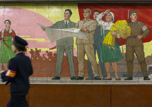 Subway employee in front of a mosaic fresco in a station, DGC, Pyongyang, North Korea
