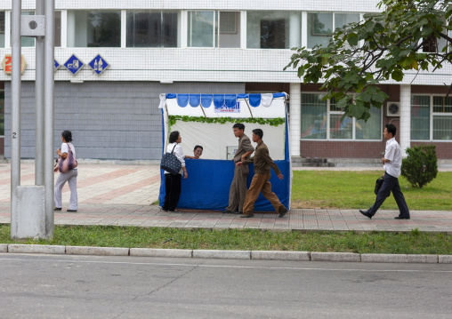 North Korean people buying drinks in a small shop in the street, DGC, Pyongyang, North Korea
