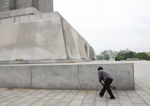 North Korean woman with a broom at the bottom of the Juche tower, DGC, Pyongyang, North Korea