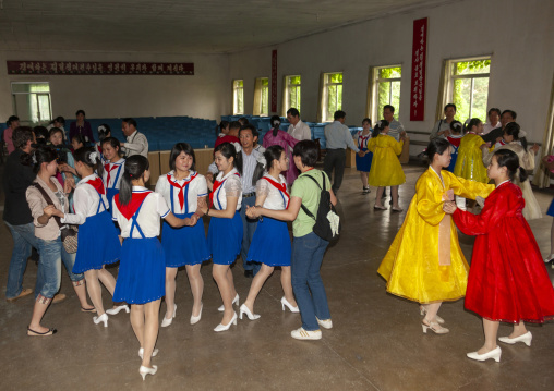 North Korean pioneer girls dancing with tourists in a school, DGC, Pyongyang, North Korea
