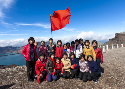 Group of students with red flag in front of lake at mount Paektu, Ryanggang, Mount Paektu, North Korea