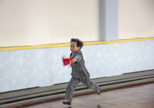 Noth Korean boy running in Kwangbok primary school, DGC, Pyongyang, North Korea
