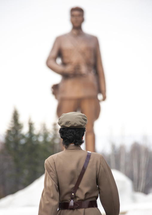 North Korean guide in mount Paektu in front of a Kim il Sung statue, Ryanggang, Samjiyon, North Korea