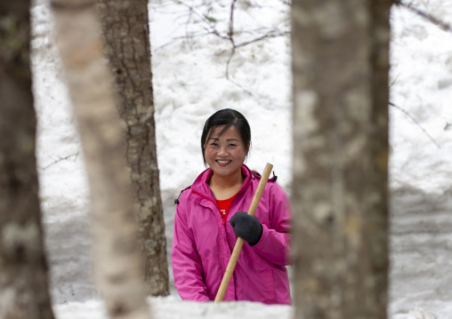 Woman removing snow in the former secret camp of the Korean resistance, Ryanggang, Samjiyon, North Korea