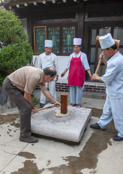 Tourist banging rice to make tteok in a restaurant, North Hwanghae, Kaesong, North Korea