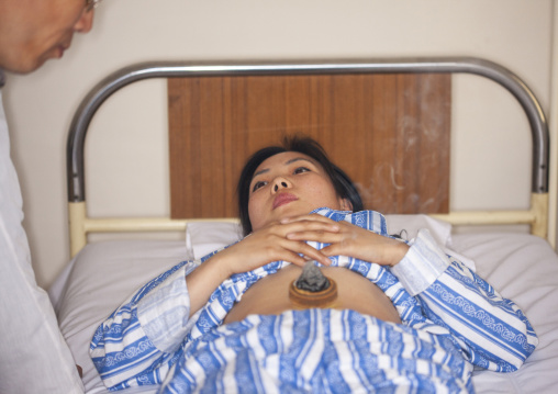 North Korean woman having traditional cupping medicine in Koryo hospital, DGC, Pyongyang, North Korea