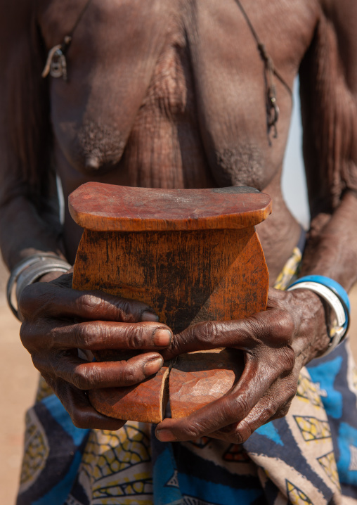 Muhacaona tribe woman holding an old headrest, Cunene Province, Oncocua, Angola