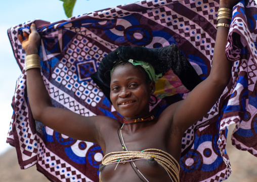 Mucubal tribe woman putting a colorful headwear, Namibe Province, Virei, Angola