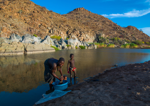 Angolan woman washing cloths in pediva hot springs, Namibe Province, Iona National Park, Angola