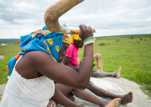 Angolan women grinding grain on a stone to make flour, Huila Province, Caconda, Angola