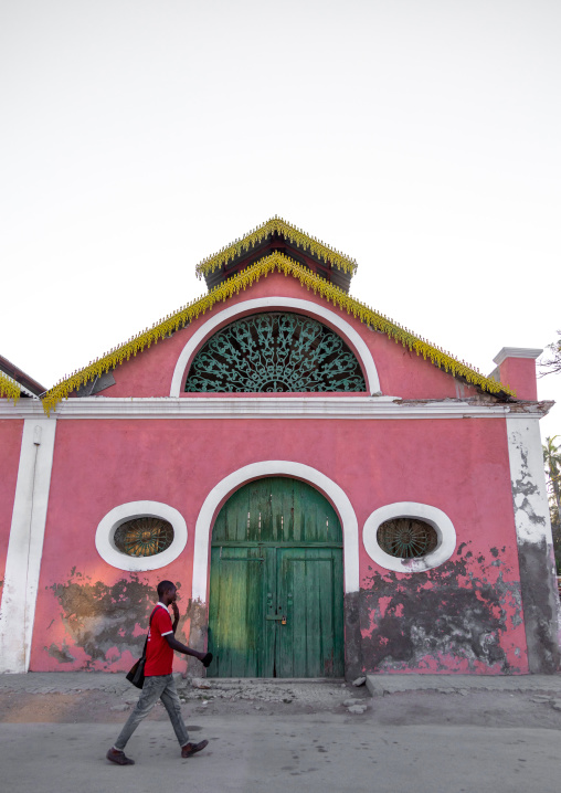 Angolan man passing in front of an old portuguese colonial warehouse, Benguela Province, Benguela, Angola