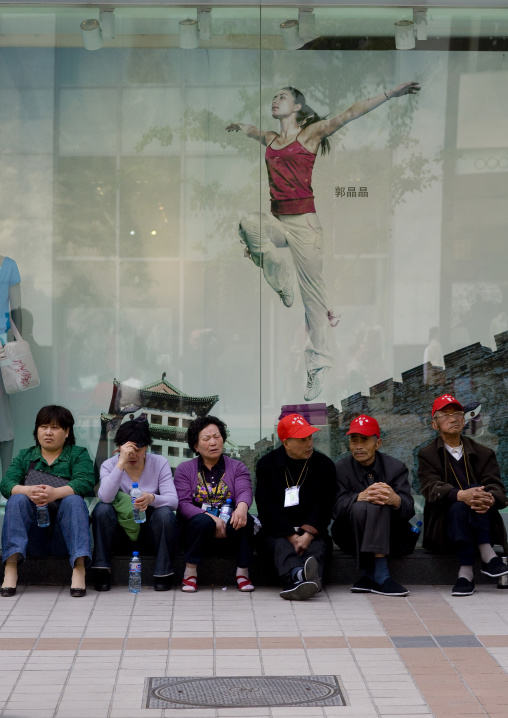 Tired Chinese Tourists In Front Of A Sport Shop, Beijing China