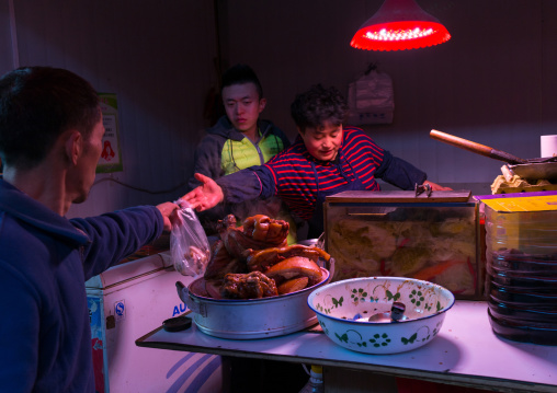 Chinese man buying some pork in a small butcher shop, Gansu province, Lanzhou, China