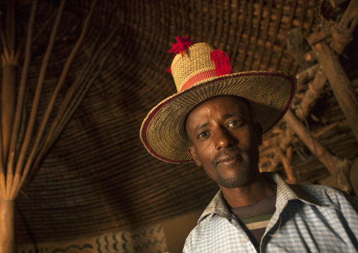 Portrait of a muslim man with tall hat inside his tukul, Alaba, Ethiopia