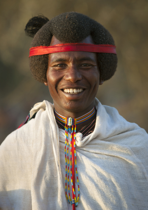 Smiling Karrayyu Man With His Gunfura Traditional Hairstyle And Red Headband In Gadaaa Ceremony, Metehara, Ethiopia