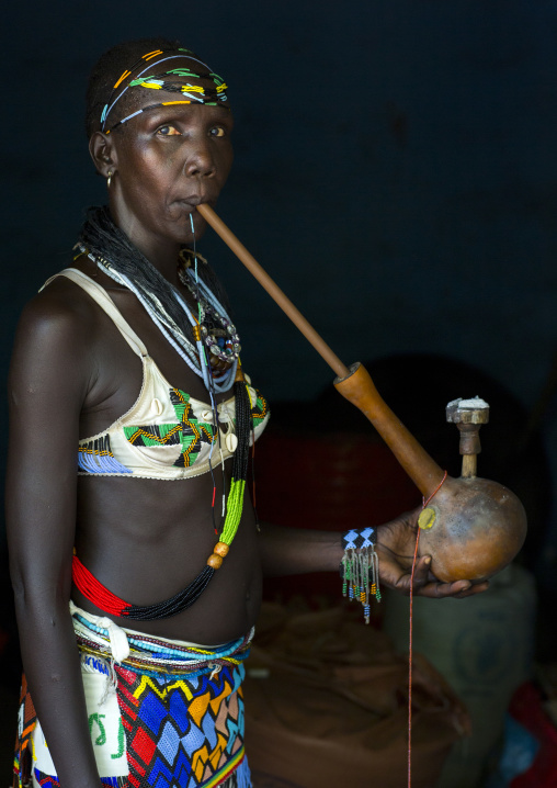 Woman Smoking A Waterpipe From Anuak Tribe In Traditional Clothing, Gambela, Ethiopia