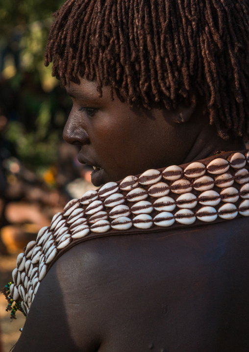 Hamer tribe woman with a shell necklace attending a bull jumping ceremony, Omo valley, Turmi, Ethiopia