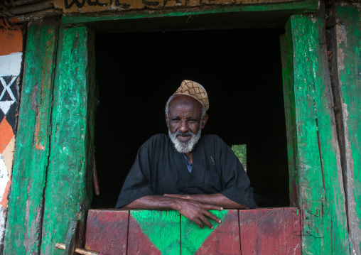 Ethiopia, Kembata, Alaba Kuito, ethiopian muslim man standing in front of his traditional painted house