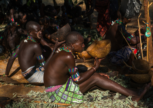 Hamer tribe whippers drinking alcohol during a bull jumping ceremony, Omo valley, Turmi, Ethiopia