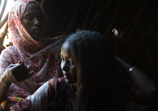 Afar woman having a traditional hairstyle inside her hut, Afar region, Afambo, Ethiopia