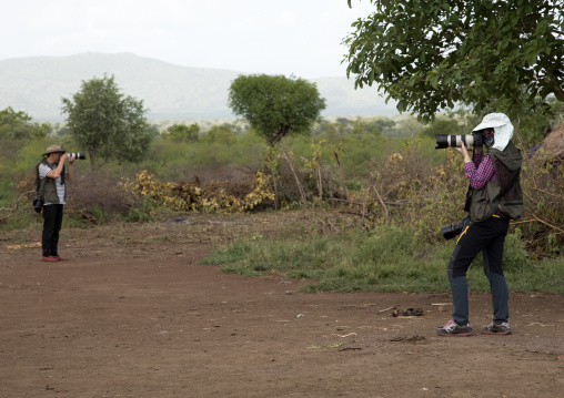 Chinese tourists taking pictures in an african village, Omo valley, Hana Mursi, Ethiopia