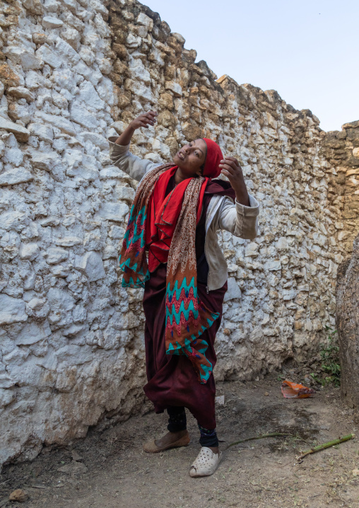 Sufi woman with a red veil into trance during a muslim ceremony, Harari Region, Harar, Ethiopia