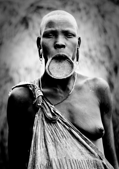 Black And White Portrait Of A Mursi Tribe Woman With Lip Plate And Enlarged Ears In Mago National Park, Omo Valley, Ethiopia