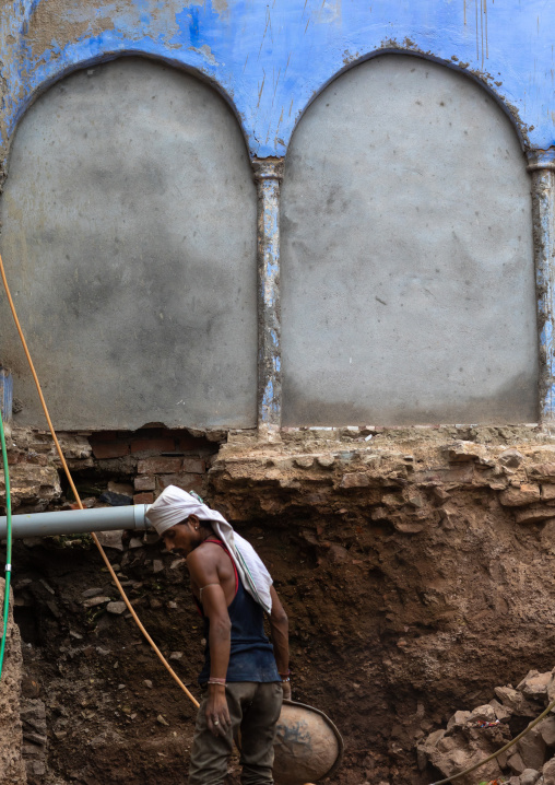 Indian worker digging in an old house, Rajasthan, Bundi, India