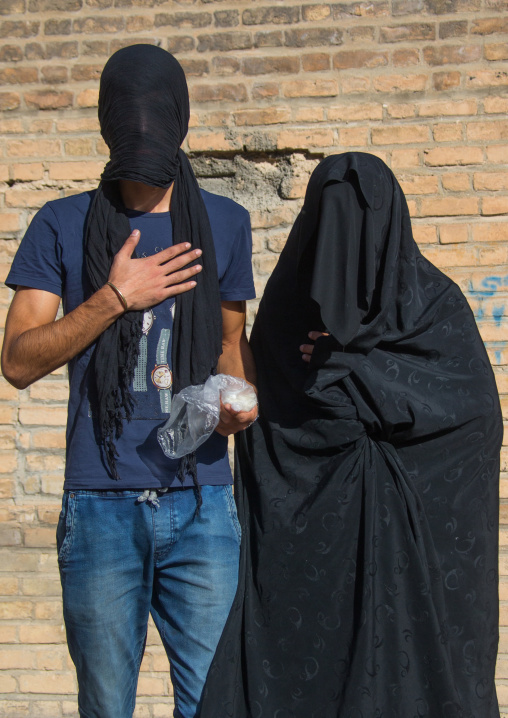 Portrait of iranian shiite muslim couple with their faces hidden by a veil mourning Imam Hussein on Tasua during the Chehel Manbar ceremony one day before Ashura, Lorestan Province, Khorramab