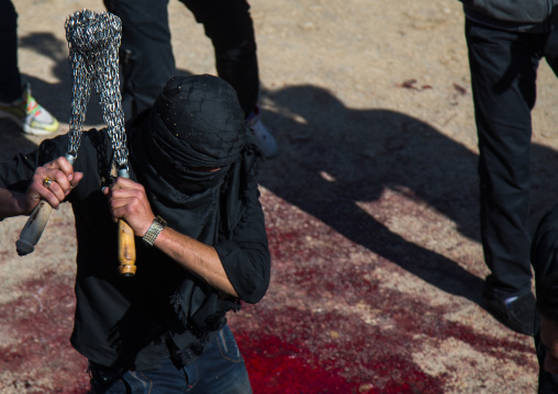 Iranian Shiite Man Covered In Mud Is Beating Himself With Iron Chains To Commemorate Ashura, The Day Of The Death Of Imam Hussein, Kurdistan Province, Bijar, Iran