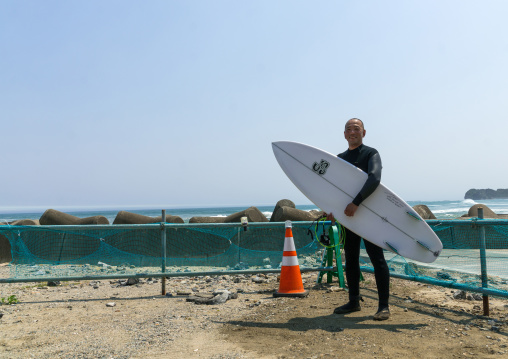 Japanese surfer in the contaminated area after the daiichi nuclear power plant irradiation, Fukushima prefecture, Tairatoyoma beach, Japan