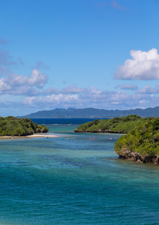Tropical lagoon with clear blue water surrounded by lush greenery in Kabira bay, Yaeyama Islands, Ishigaki, Japan