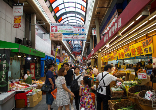 Shoppers walk along Kuromon Ichiba market, Kansai region, Osaka, Japan