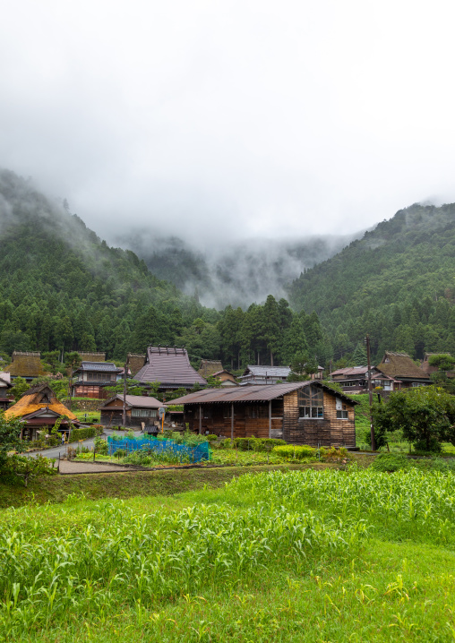 Thatched roofed houses in a traditional village in the fog, Kyoto Prefecture, Miyama, Japan