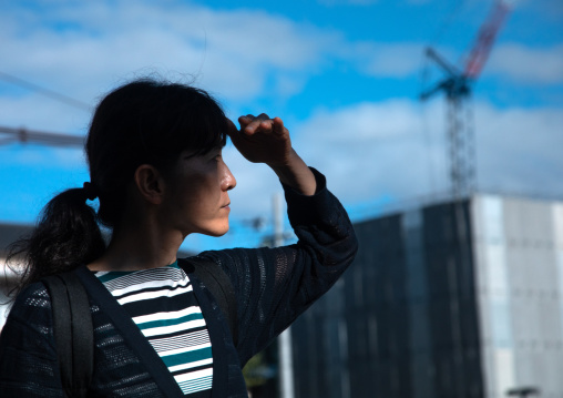 Japanese woman looking away and blocking sun with hand, Kansai region, Kyoto, Japan